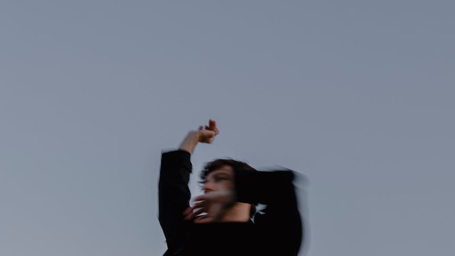 Silhouette of a person in a dynamic movement pose against a dark background.